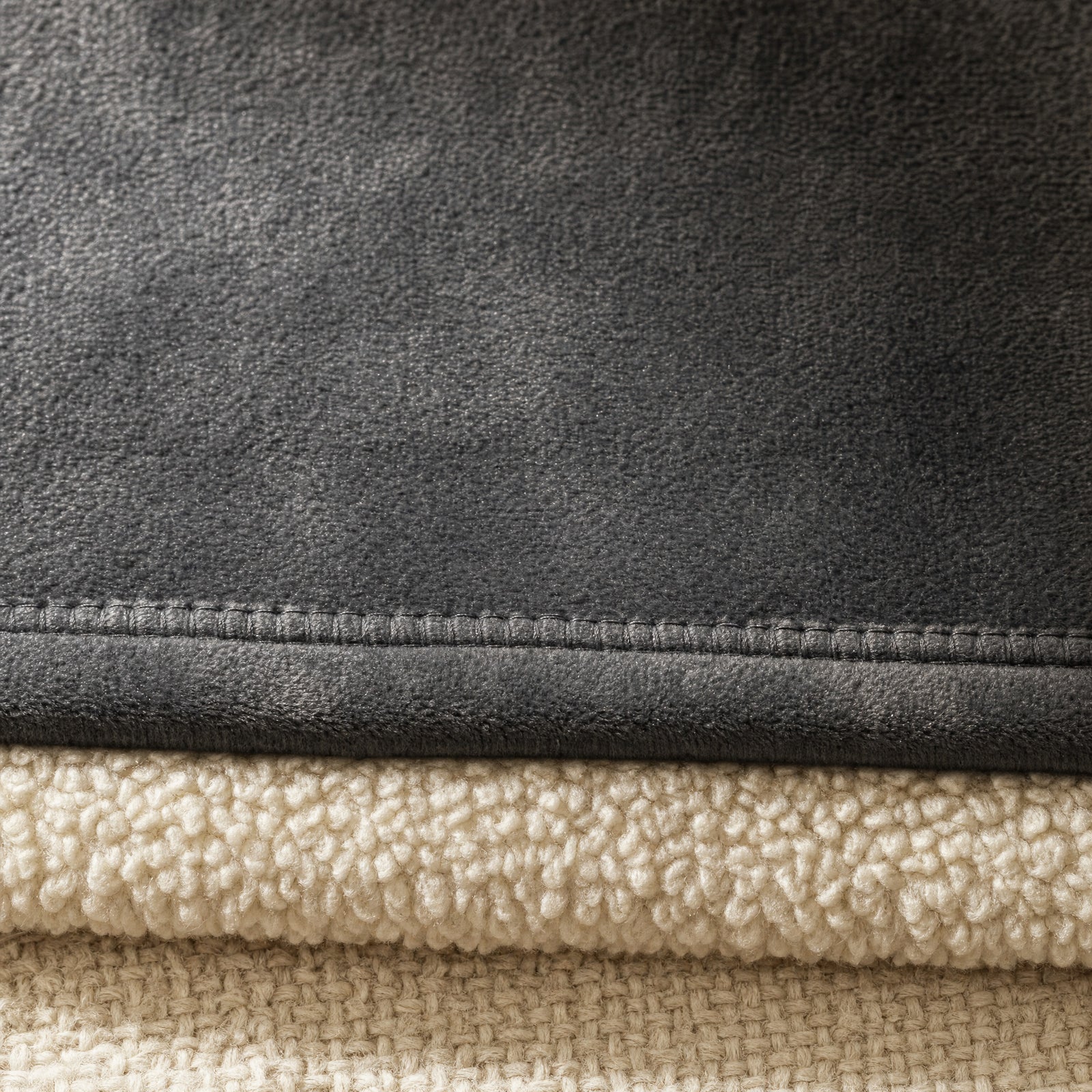 Close-up of the brushed charcoal flannel face and cream sherpa reverse at the hemmed edge
